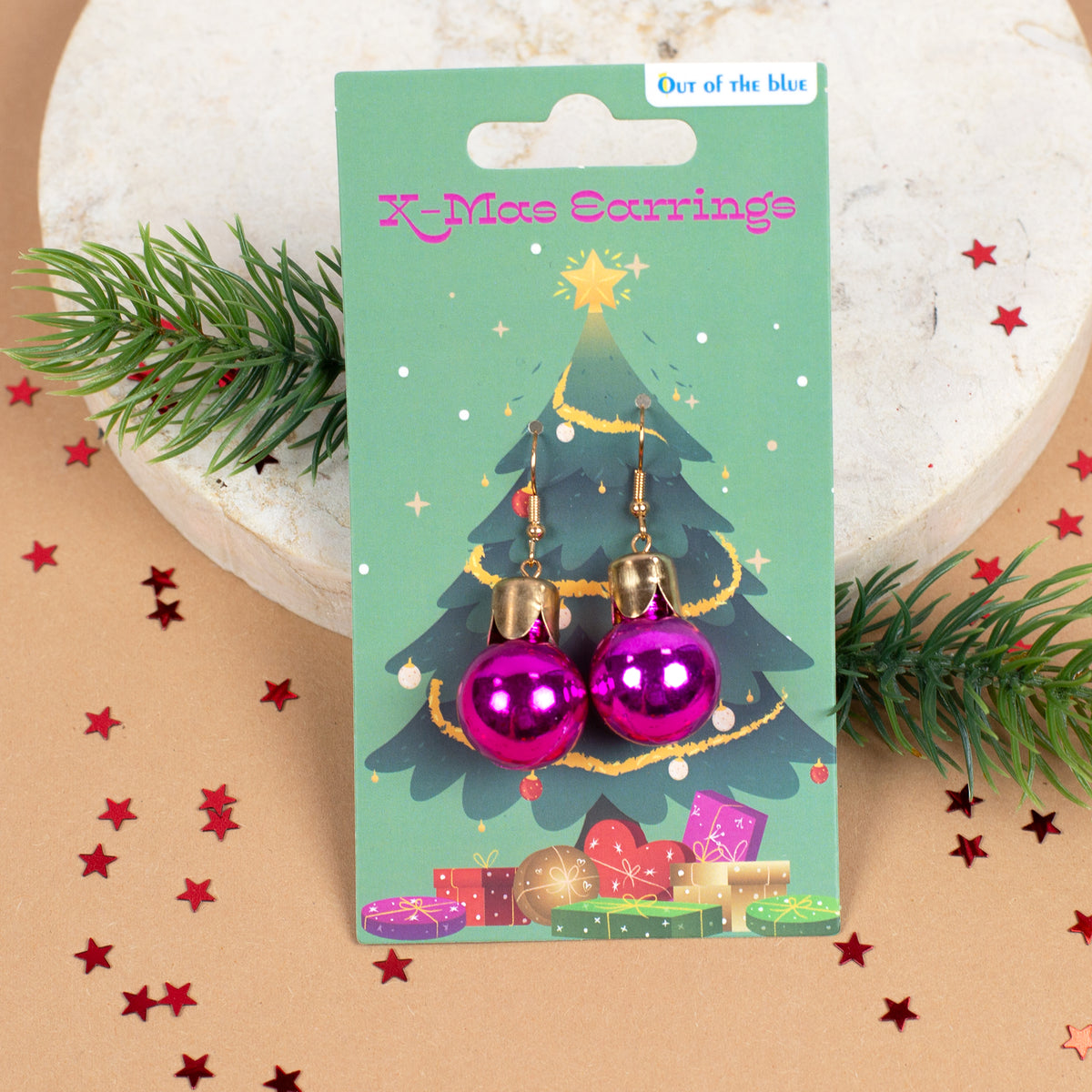 Pinke Weihnachtskugel-Ohrringe auf Weihnachtskarte mit Tannenbaum-Motiv