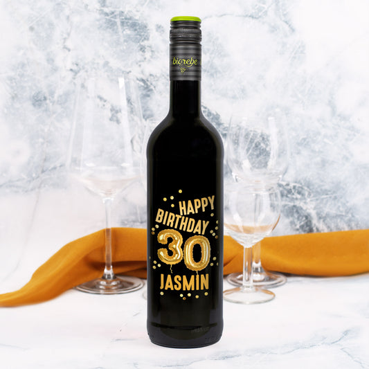 Weinflasche mit schwarzem Etikett „Happy Birthday 30 Jasmin“ in goldener Ballon-Optik, dekoriert mit goldenen Konfetti-Elementen