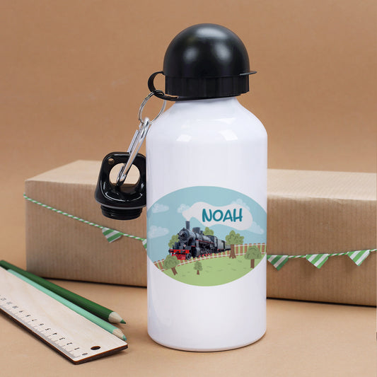 Personalisierte Kinder-Trinkflasche mit Dampflok-Motiv und Name „Noah“, stehend vor Geschenkverpackung