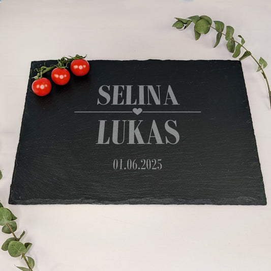 Schieferplatte mit Gravur „SELINA ♥ LUKAS“ und Datum 01.06.2025, dekoriert mit kleinen Tomaten und Eukalyptuszweig