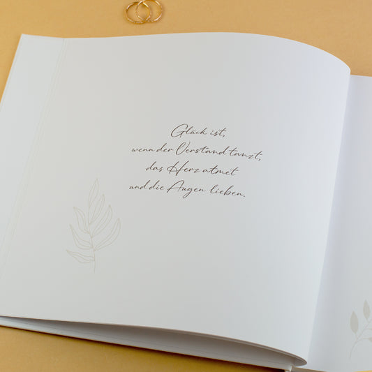 Innenseite Gästebuch Hochzeit mit Zitat „Glück ist …“ und floraler Verzierung
