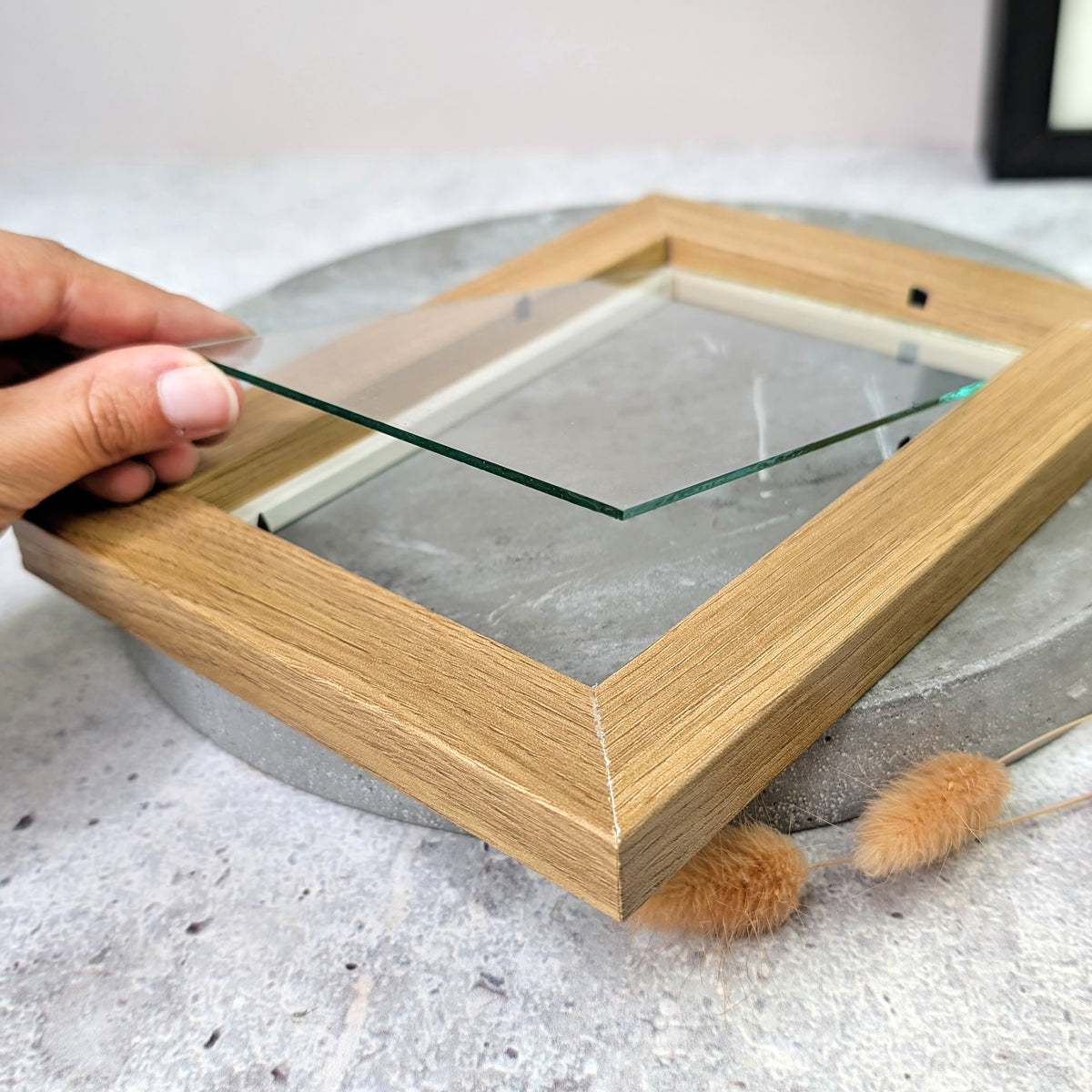 Glas des Bilderrahmen aus Holz mit weißem Innenrand herausgenommen