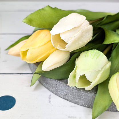 Detailaufnahme von vier hochwertigen Tulpenköpfen in Weiß, Cremegelb, Pastellgrün und zartem Rosa aus recyceltem Seidenmaterial