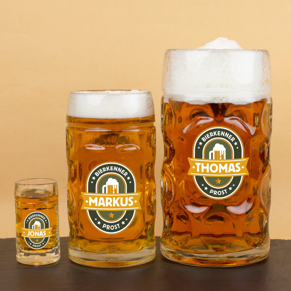 Vergleichsansicht aller drei Bierkrüge: 1 l, 0,5 l und 4 cl mit Bierkenner-Motiv und Wunschnamen nebeneinander