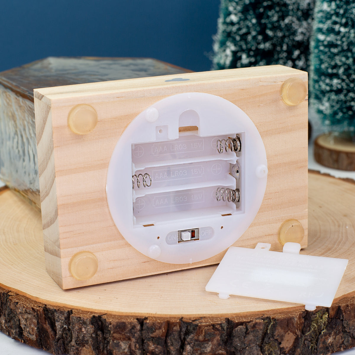 Offenes Batteriefach des LED-Hauses von Leonardo mit Platz für drei AAA-Batterien – Detailaufnahme des Holzsockels.