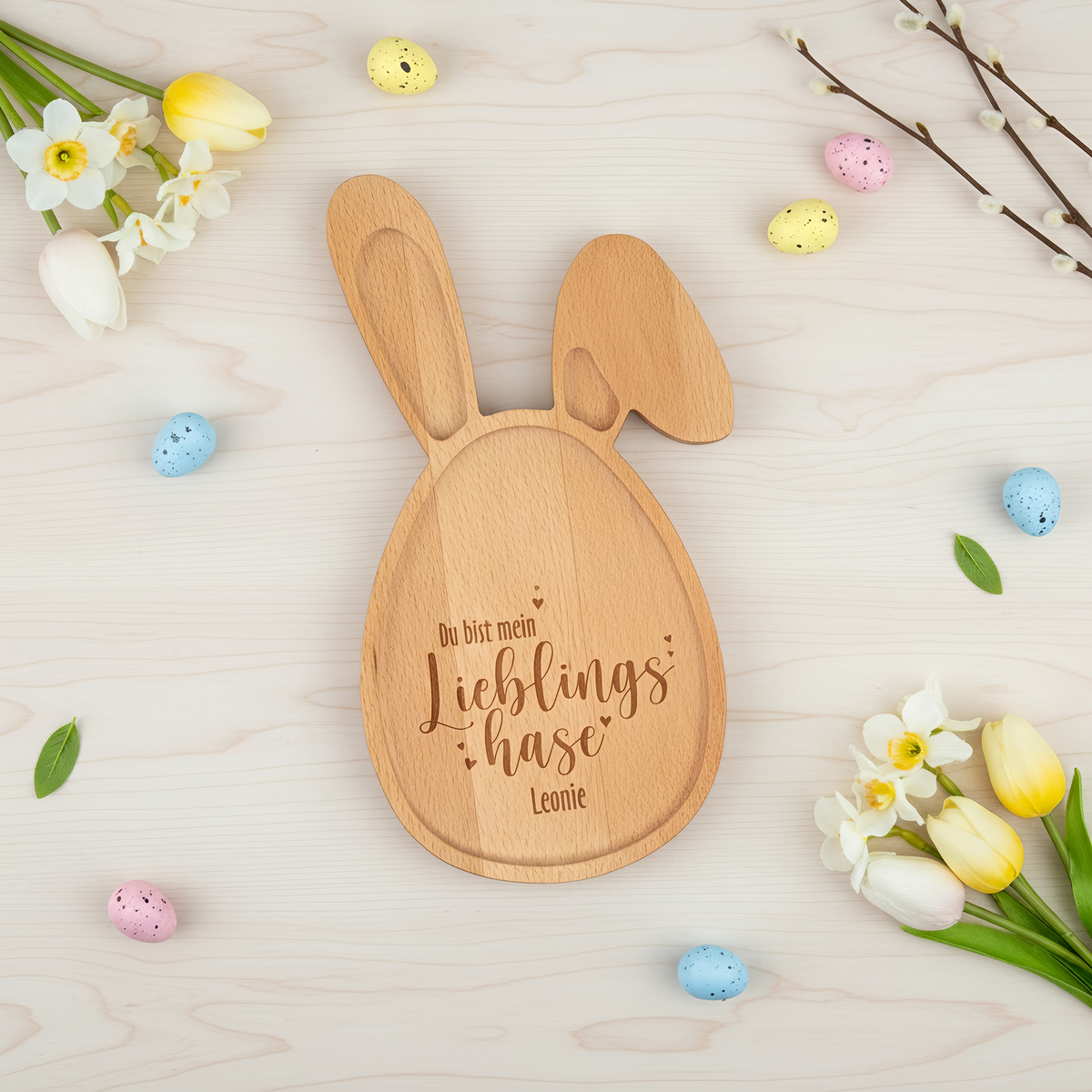 Personalisiertes Hasenbrett mit Gravur „Lieblingshase Leonie“ auf hellem Hintergrund aus Holz mit Osterdekoration