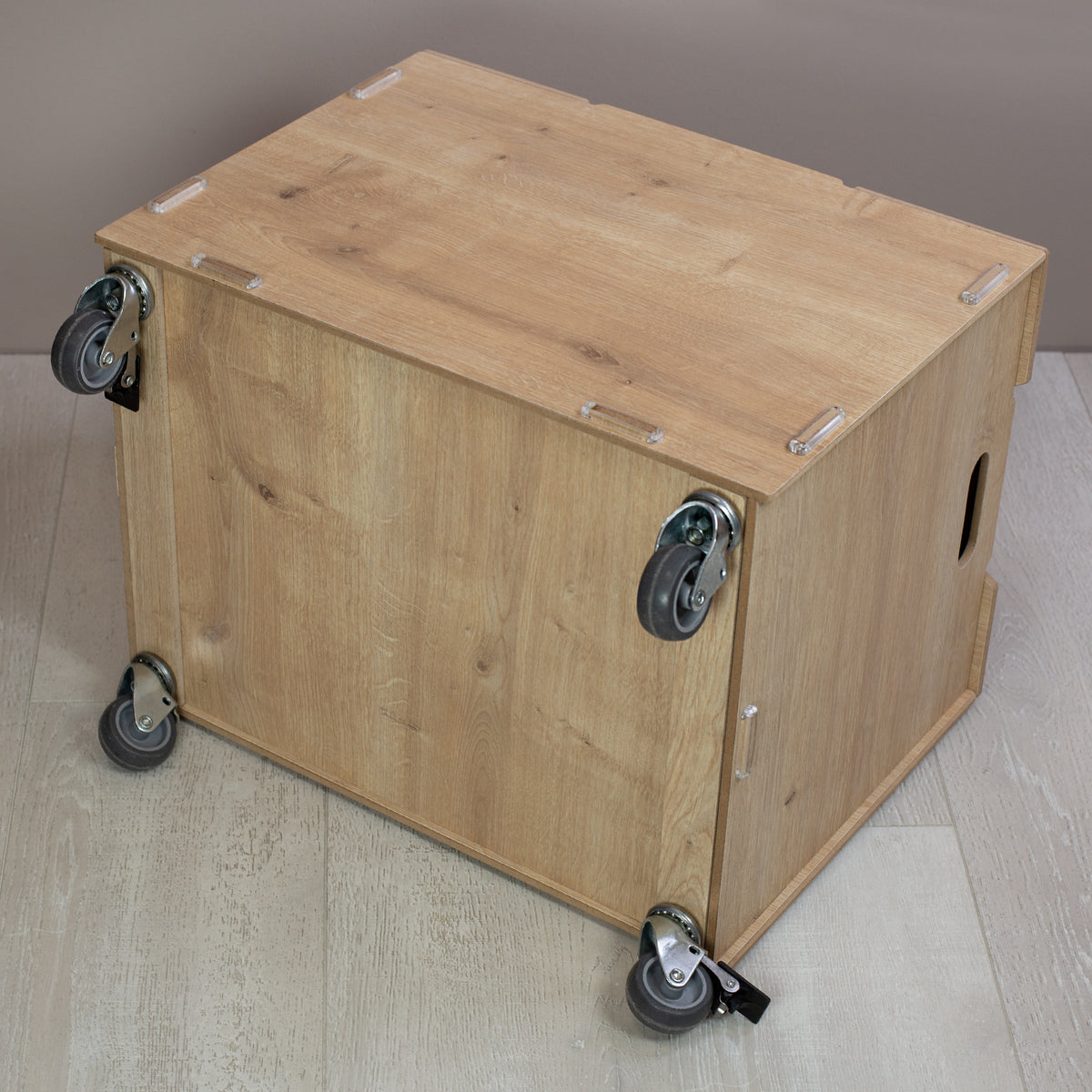 Ansicht von seitlich unten der Holz-Rollbox mit vier stabilen Rollen, zwei davon mit Feststellbremse, schlichte Darstellung ohne Personalisierung
