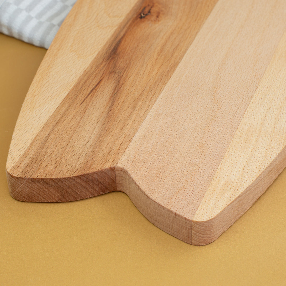 Detailaufnahme vom Griffbereich des Surfbrett-Servierbretts aus Holz mit abgerundeter Kante