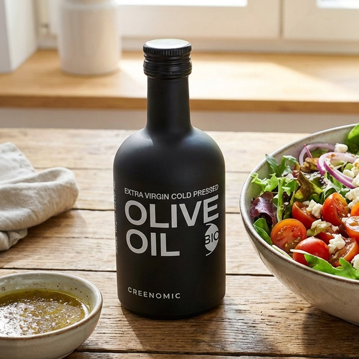Schwarzes Greenomic Olivenöl BIO nativ extra 100 ml auf Holztisch in Küche