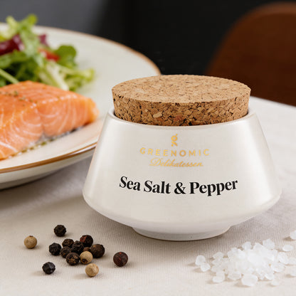Sea Salt & Pepper im Keramiktopf neben Lachsfilet und frischem Salat angerichtet