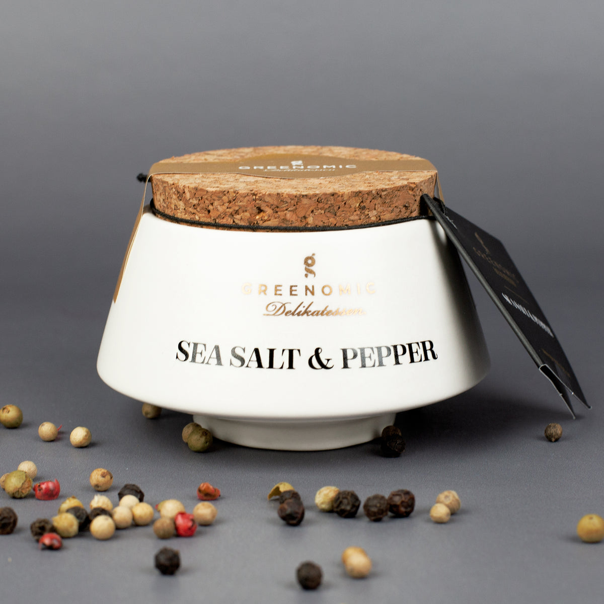 Sea Salt & Pepper Gewürz von Greenomic mit Pfefferkörnern dekoriert auf dunklem Untergrund
