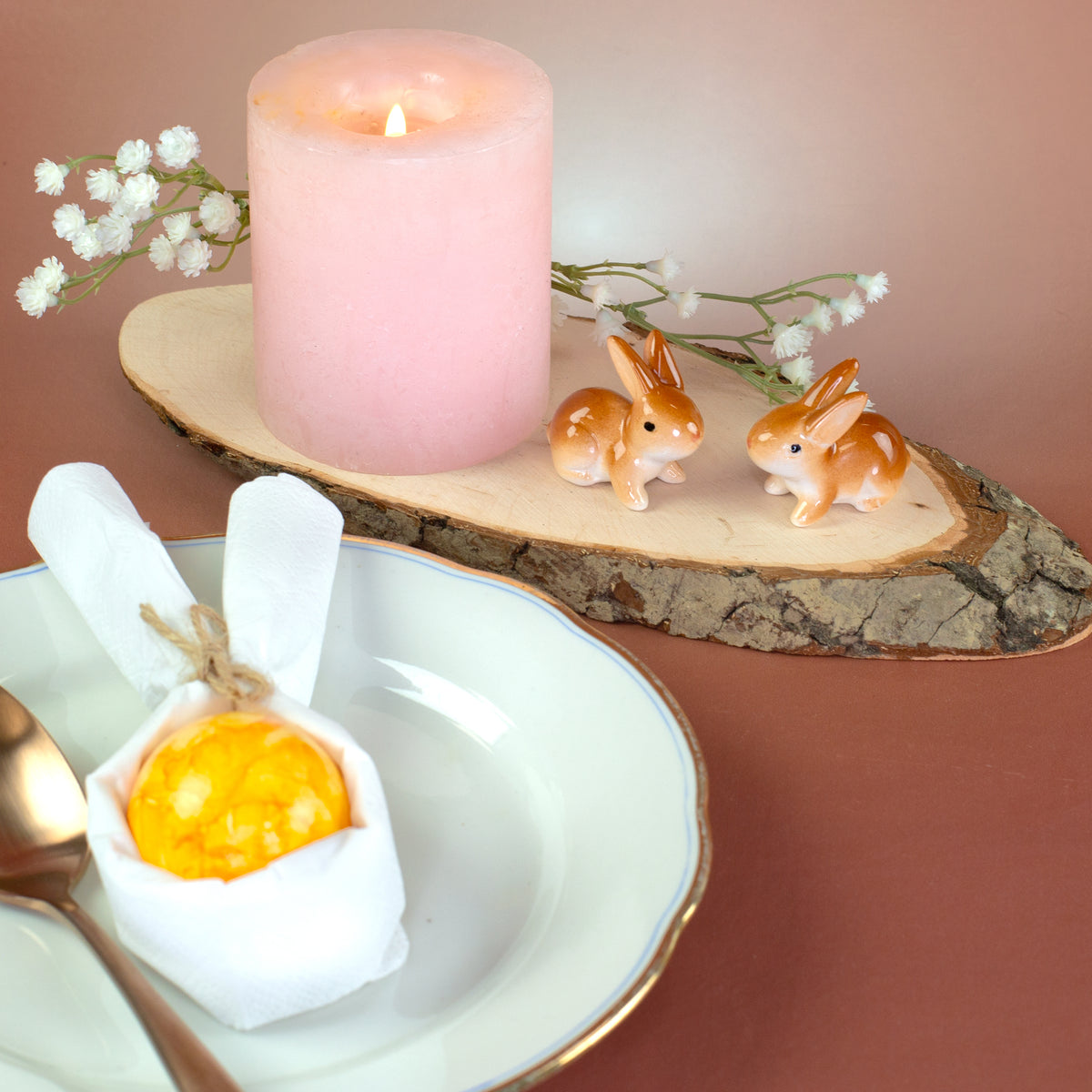 Braun-weißes Keramik-Häschen Osterfigur auf Holzplatte mit Frühlingsdeko