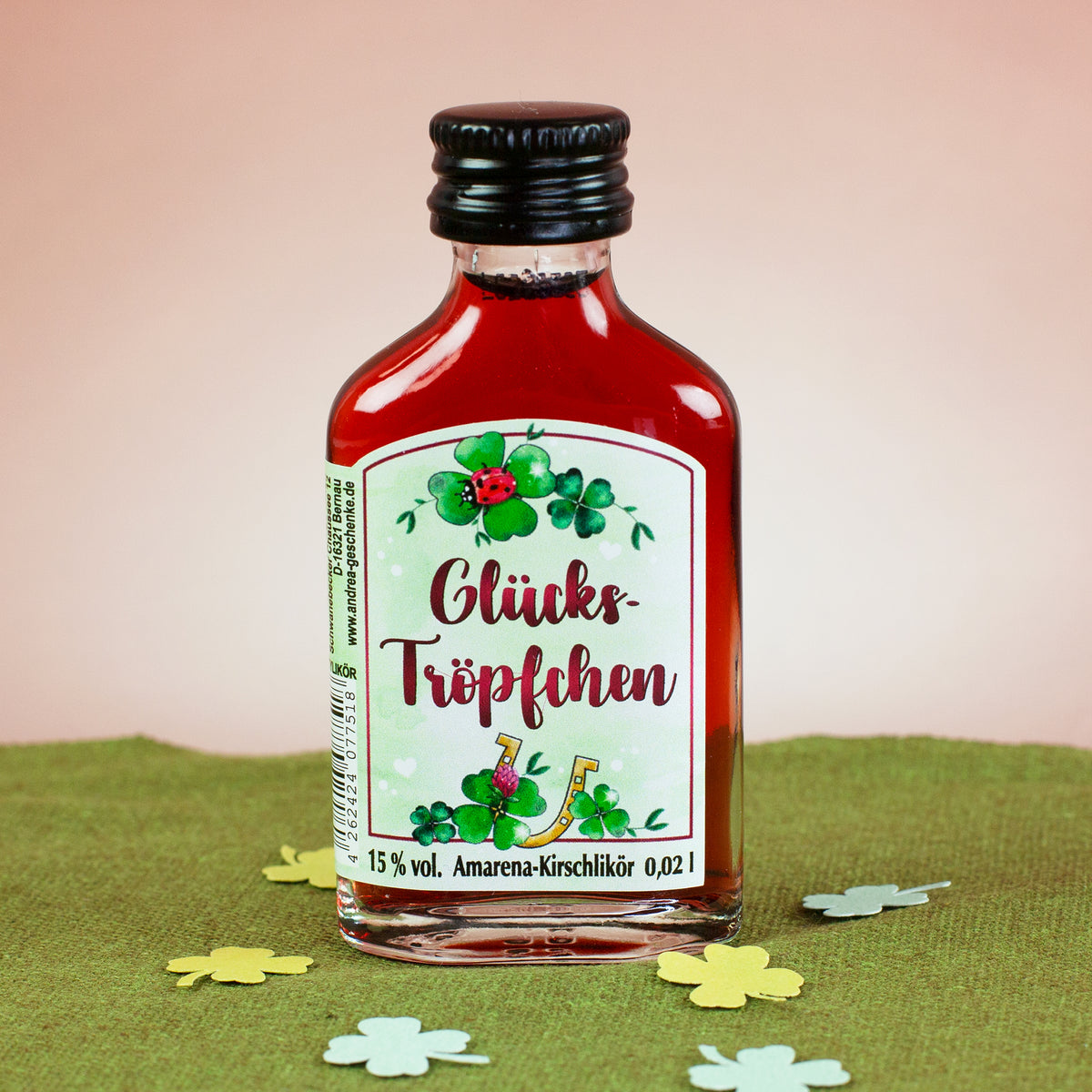 Glücks-Tröpfchen Likörflasche mit Kleeblatt und Marienkäfer auf grünem Untergrund
