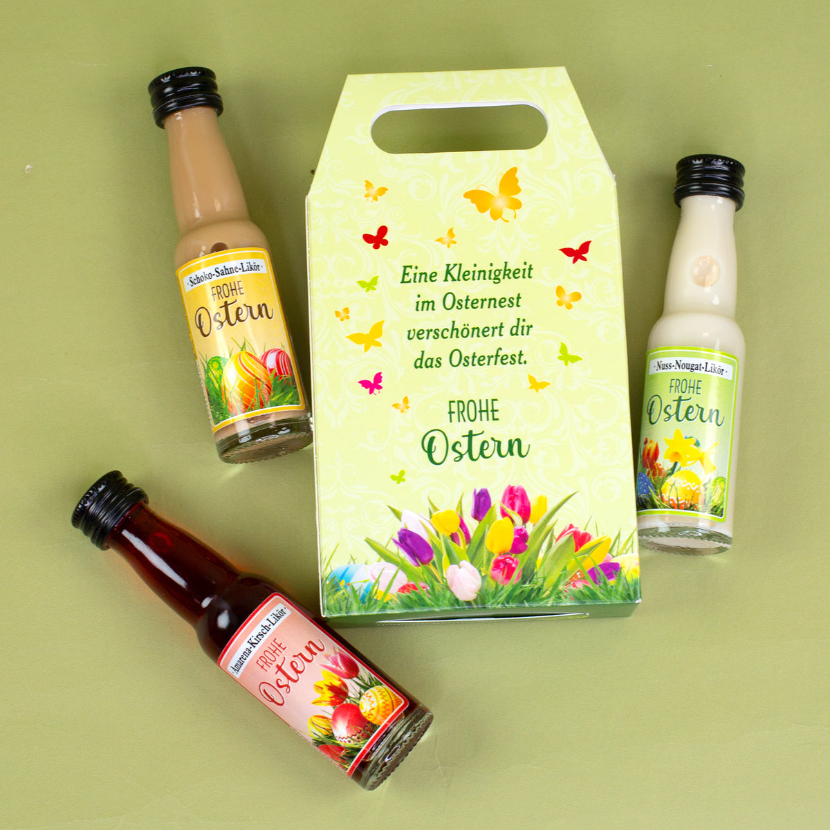 Likör Geschenkset Frohe Ostern mit drei Mini Likören vor grüner Osterdekoration