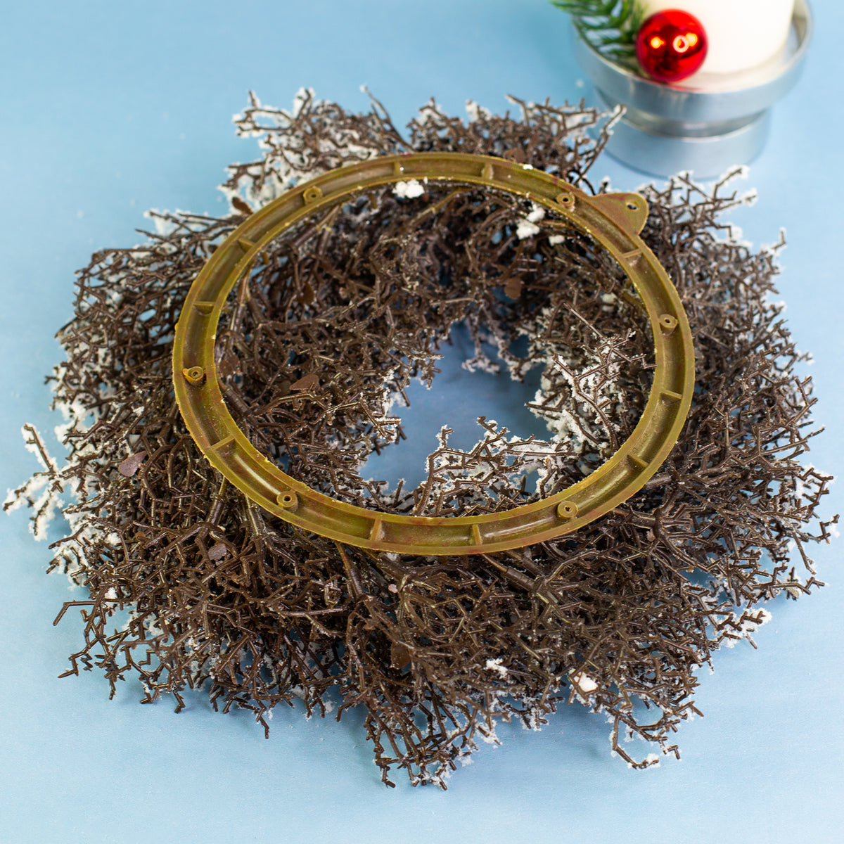 Rückseite des verschneiten Adventskranzes mit Aufhängeöse für Wand- oder Türdekoration
