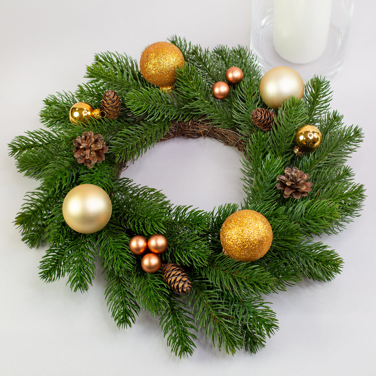 Kunst-Tannenkranz Ø 35 cm mit goldener Weihnachtsdeko und Kugeln auf Tisch