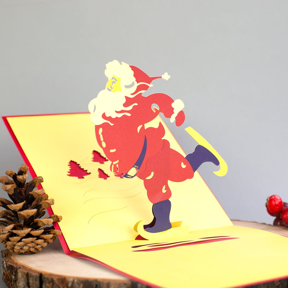Geöffnete 3D-Klappkarte zeigt einen fröhlichen Weihnachtsmann auf Schlittschuhen als Scherenschnitt-Motiv.