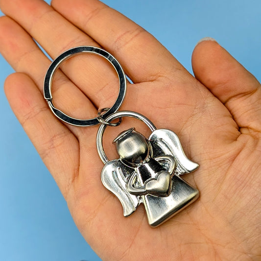 Schutzengel-Schlüsselanhänger aus Metall in silber, gehalten in einer Hand zur Größenansicht