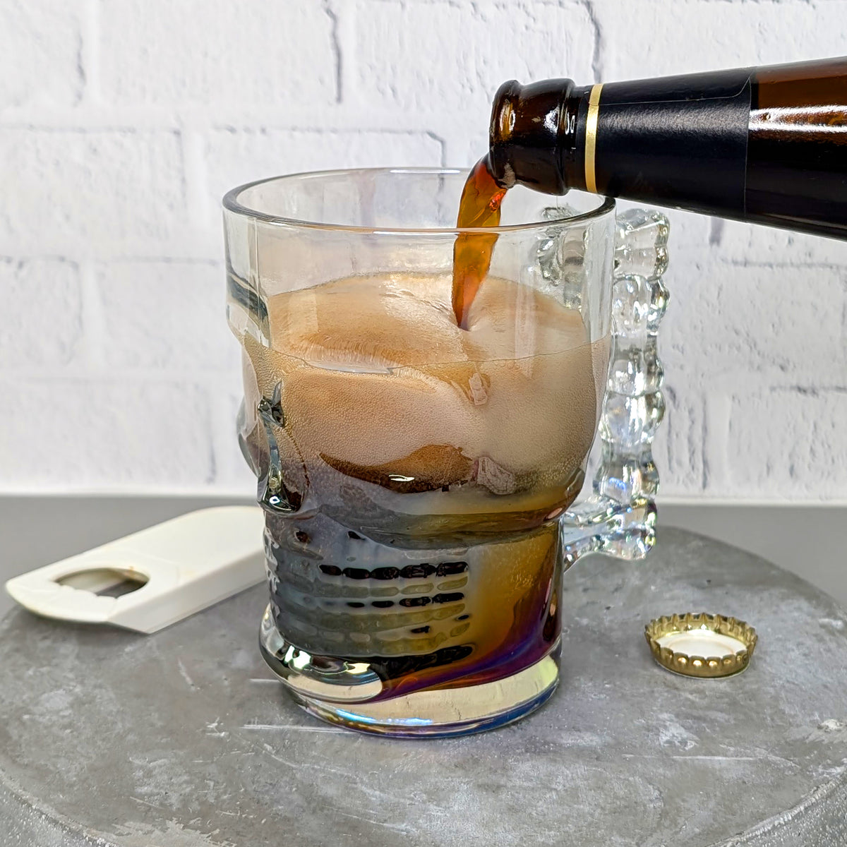 Ein dunkles Bier wird in das Totenkopfglas gegossen