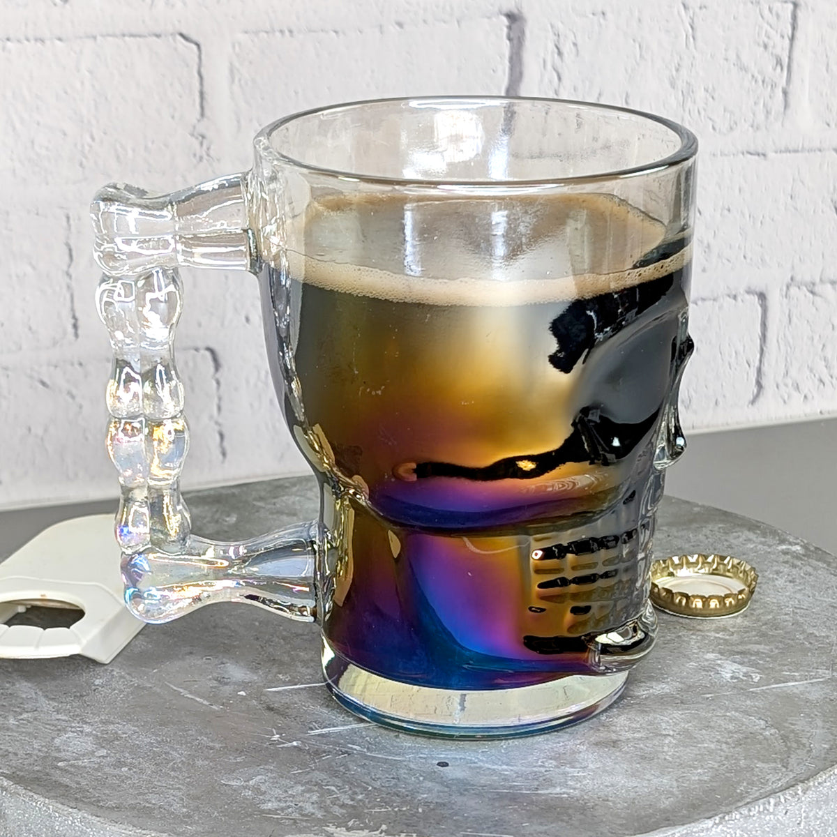 Ansicht des Totenkopfglases mit Bier von der Seite mit Knochen-Griffs und irisierendem Effekt