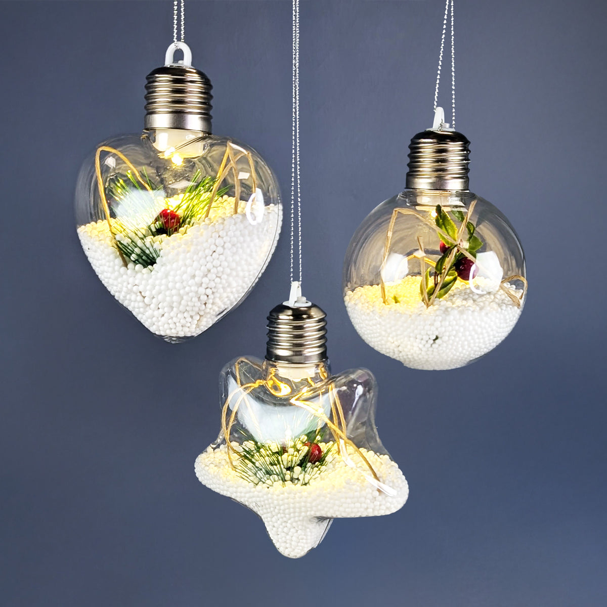 LED-Weihnachtskugeln in den Formen Kugel, Herz und Stern mit winterlicher Füllung und warmweißem Licht.
