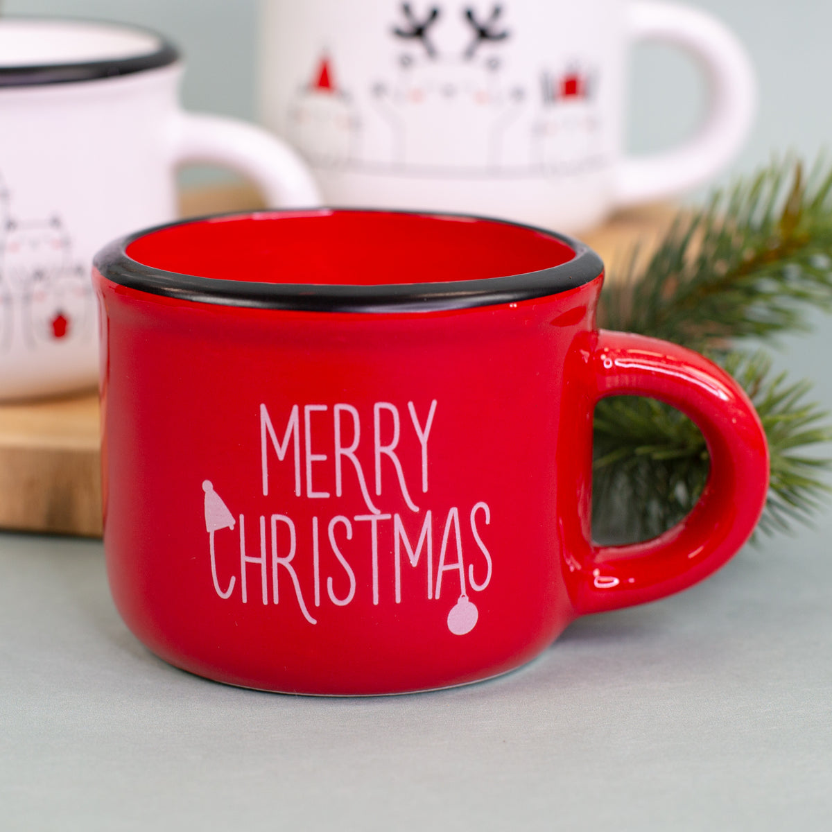 Rote Dolomitetasse mit weißem Merry-Christmas-Schriftzug als Kerze