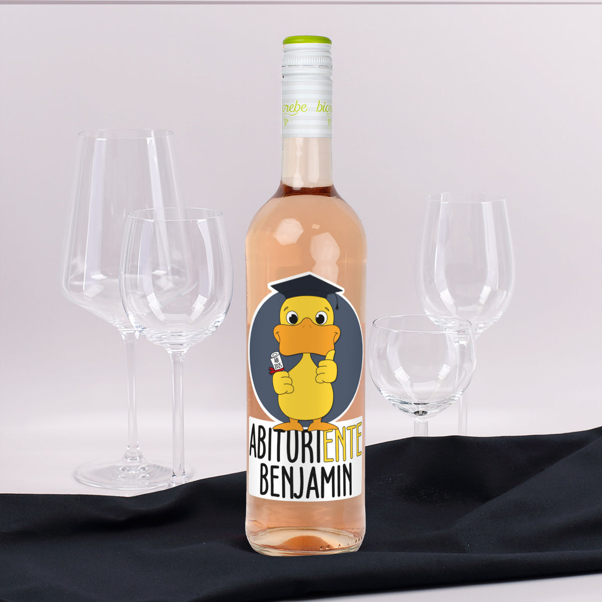 Personalisierte Weinflasche mit Roséwein, Etikett „Abituriente Benjamin“ und gelber Ente mit Doktorhut und Diplom, dekoriert mit Gläsern