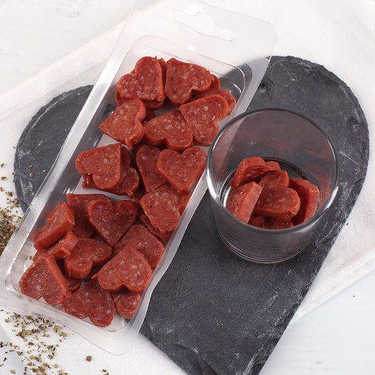 Offene Packung mit herzförmigen Mini-Salami-Pralinen als herzhafter Snack zu Weihnachten.