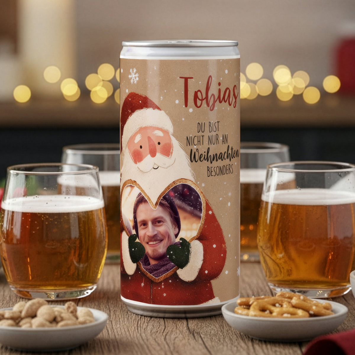 Personalisierte Weihnachtsbier-Dose mit Fotoherz und Name, dekoriert zwischen Biergläsern auf einer festlichen Holzoberfläche.