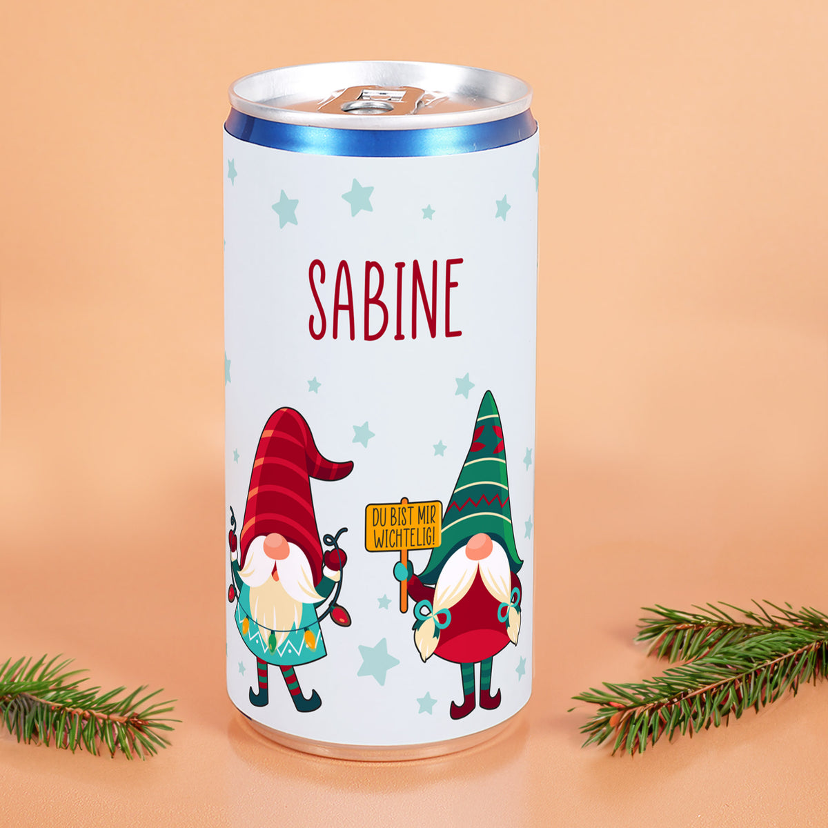 Weihnachts-Prosecco-Dose mit Wichtel-Motiv und personalisiertem Namen „Sabine“ vor orangefarbenem Hintergrund
