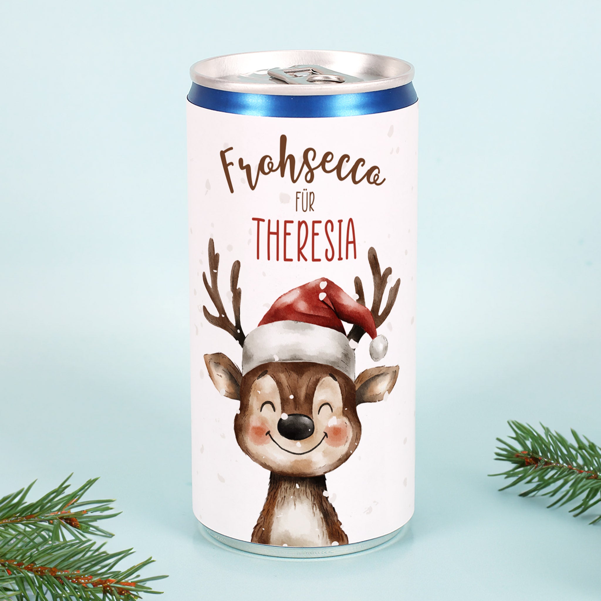 Frohsecco-Dose mit personalisiertem Namen „Theresia“ und Rentier-Design auf blauem Hintergrund mit Tannenzweigen