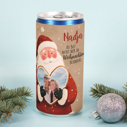 Weihnachtsdose mit Foto im Herzrahmen, festlichem Weihnachtsmann und Spruch, dekoriert mit silberner Kugel und Tannenzweig.
