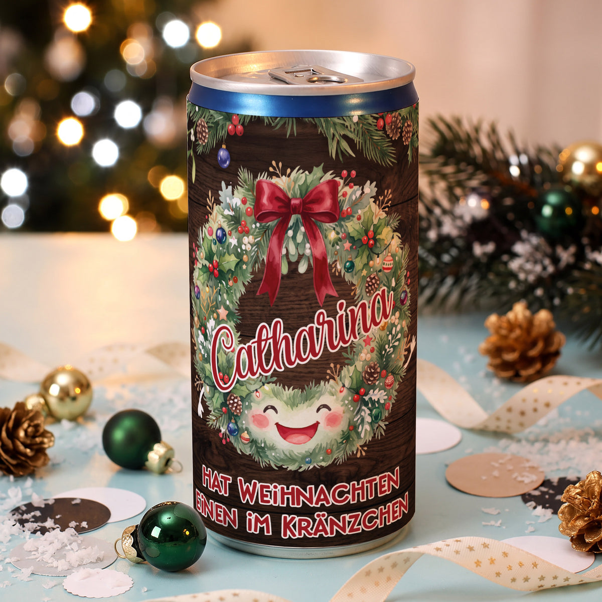 Personalisierte Secco-Dose mit Name Catharina, Weihnachtskranz und Spruch „Hat Weihnachten einen im Kränzchen“ zwischen Weihnachtsdekoration