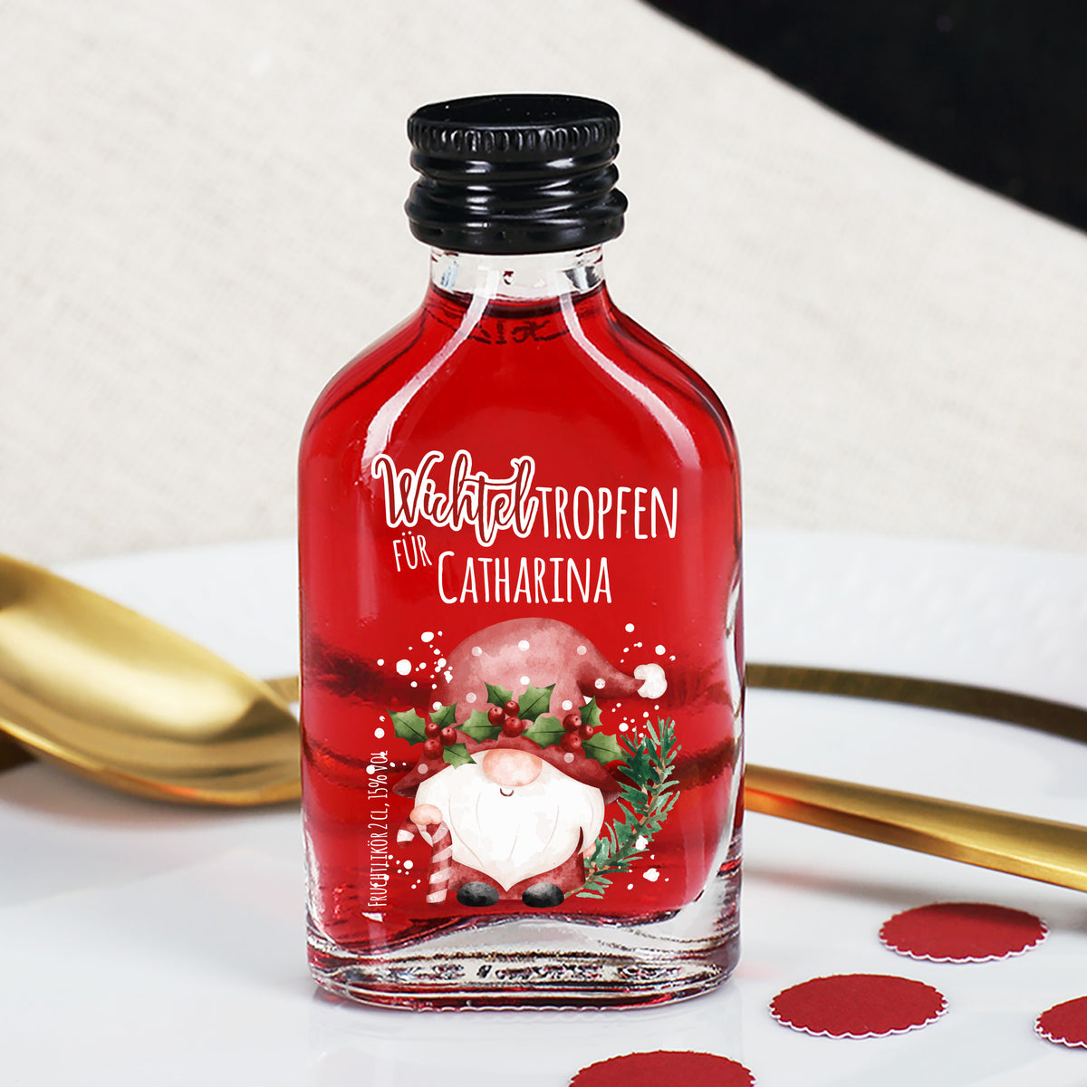 Mini-Likörflasche mit rotem Fruchtlikör und Wichtelmotiv, personalisiert mit Name, dekorative Tischszene.