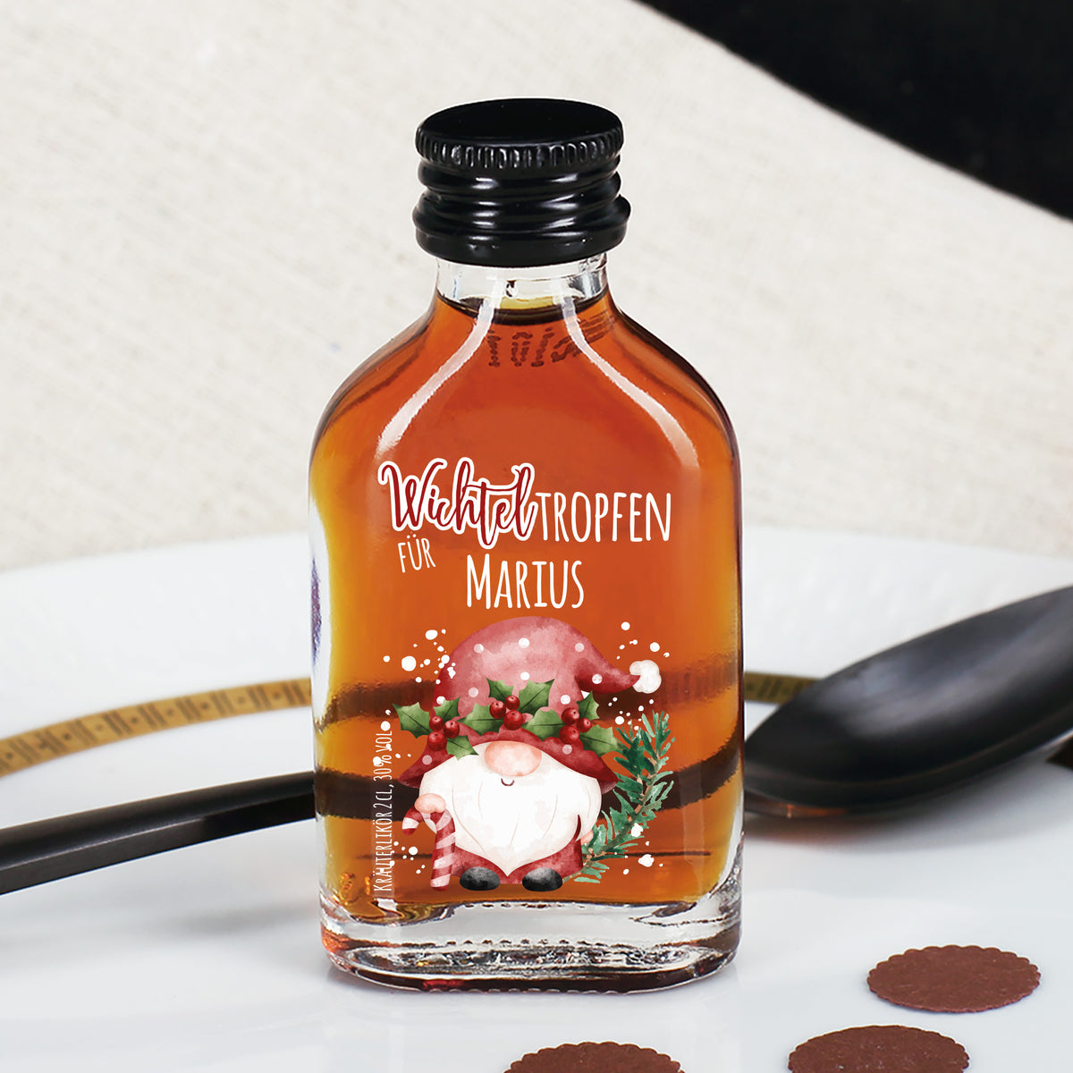 Mini-Kräuterlikörflasche mit Wichtelmotiv und Namenspersonalisierung in festlicher Tischszene.