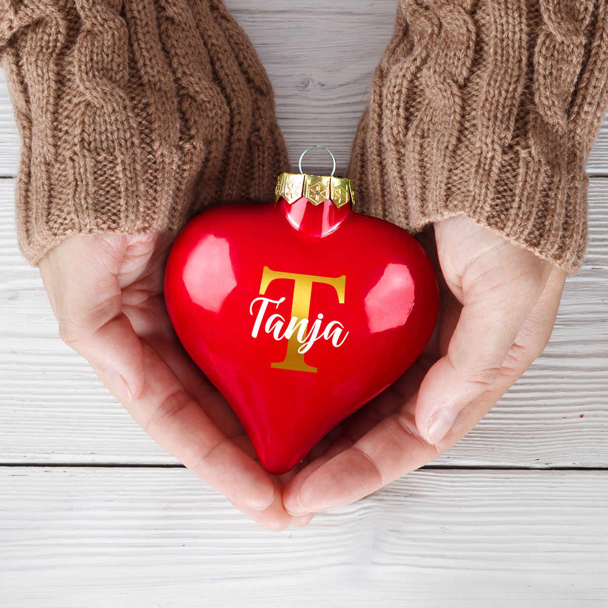 Personalisierte Weihnachtskugel mit Initiale T und Name Tanja in Händen gehalten