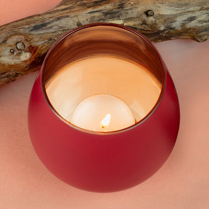 Rotes Windlicht mit warmem Kerzenlicht und kupferfarbenem Innenraum