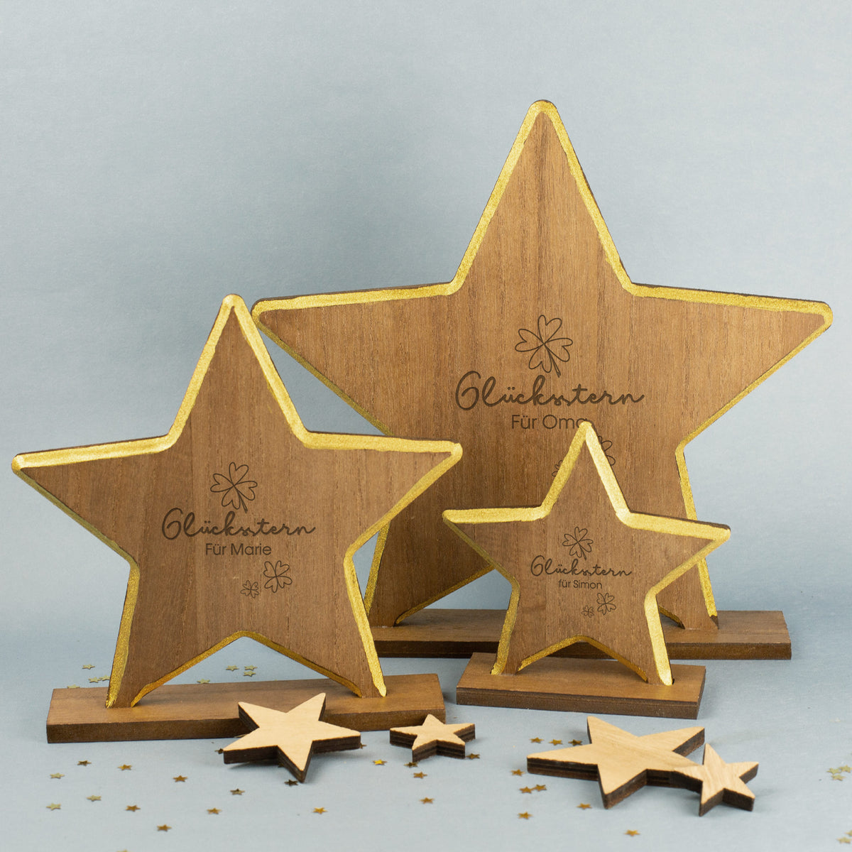 Alle drei Größen vom Holzstern mit Gravur Glücksstern, Kleeblattmotiven und personalisiertem Namen, goldene Umrandung