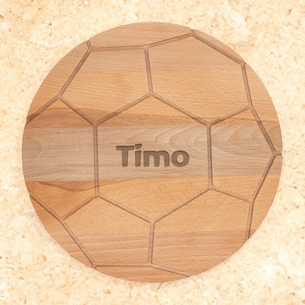 Rundes Holzbrett im Fußball-Look mit Gravur Timo auf hellem Untergrund