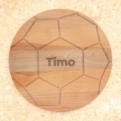 Rundes Holzbrett im Fußball-Look mit Gravur Timo auf hellem Untergrund