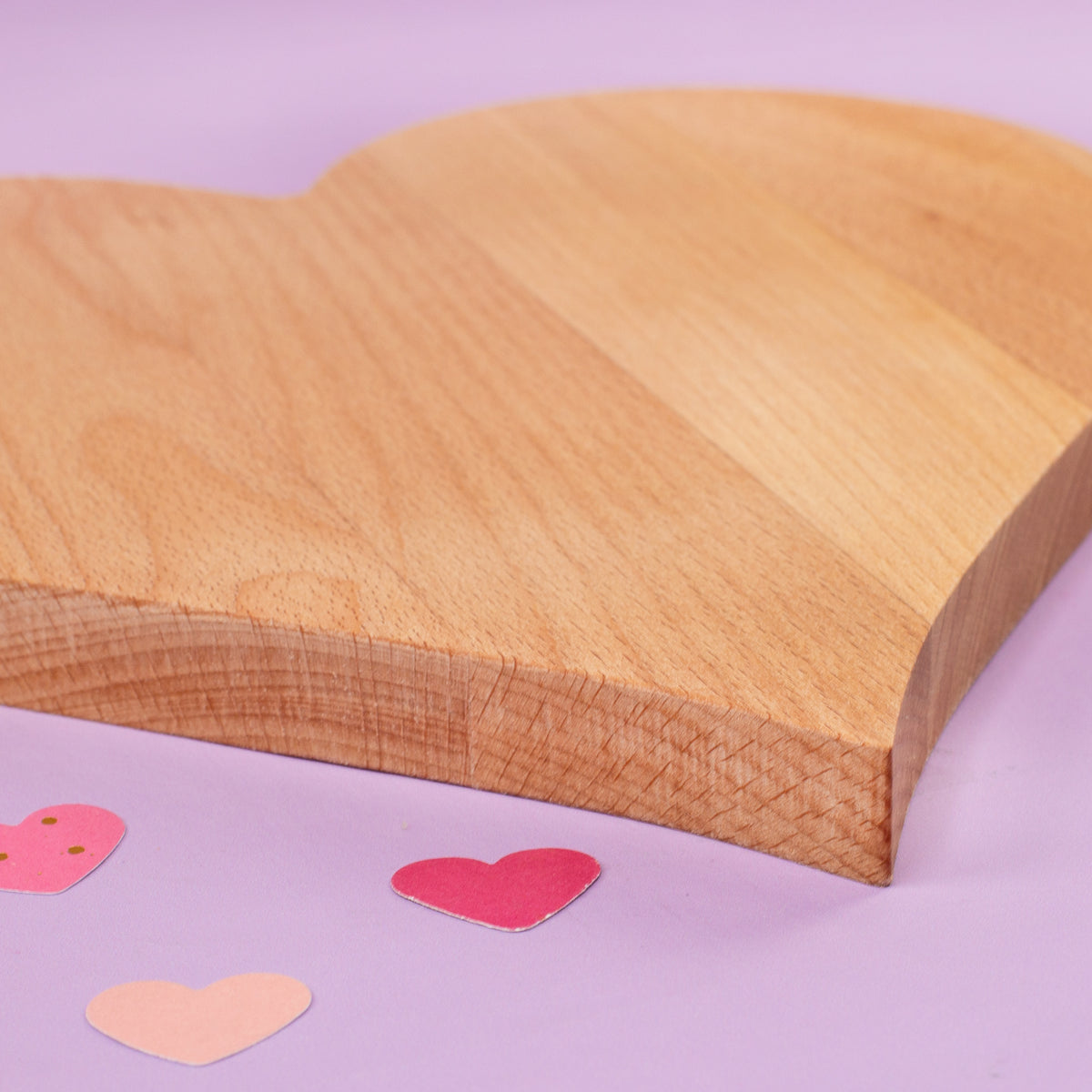Seitenansicht eines herzförmigen Holz-Servierbretts mit sichtbarer Materialstärke