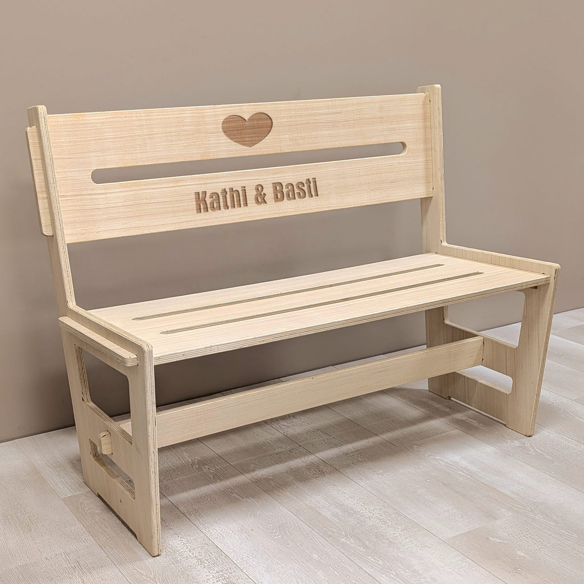 Holzbank mit Gravur „Kathi & Basti“ in Innenraumumgebung – perfekte Geschenkidee zur Hochzeit oder zum Jahrestag