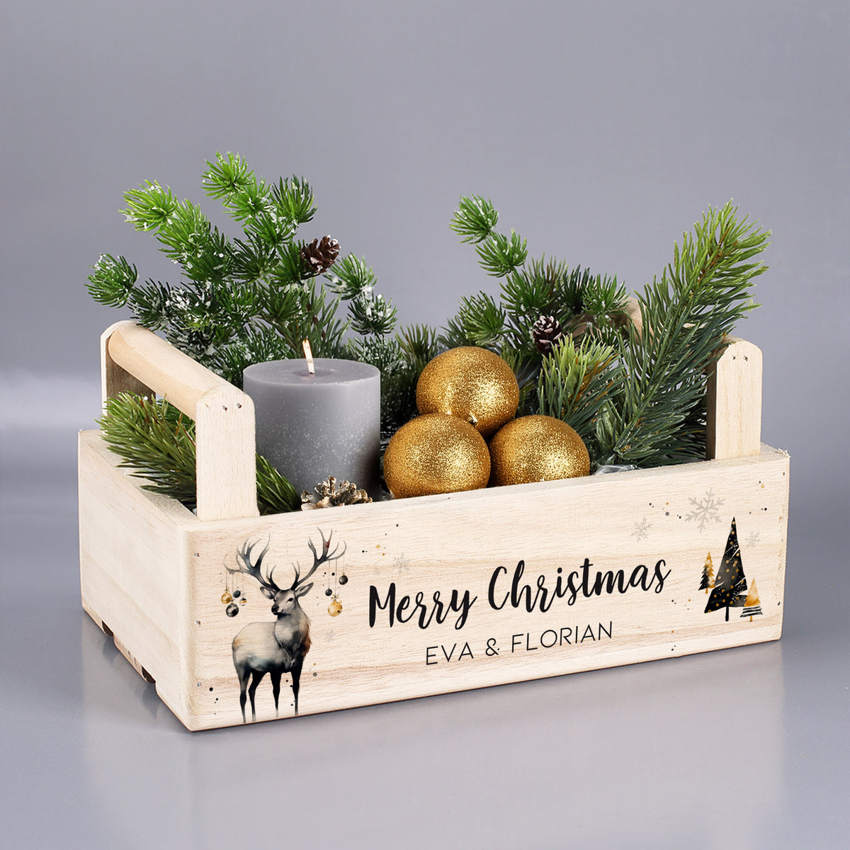 Holzkorb zu Weihnachten mit Hirschmotiv, Tannengrün und goldenen Kugeln dekoriert