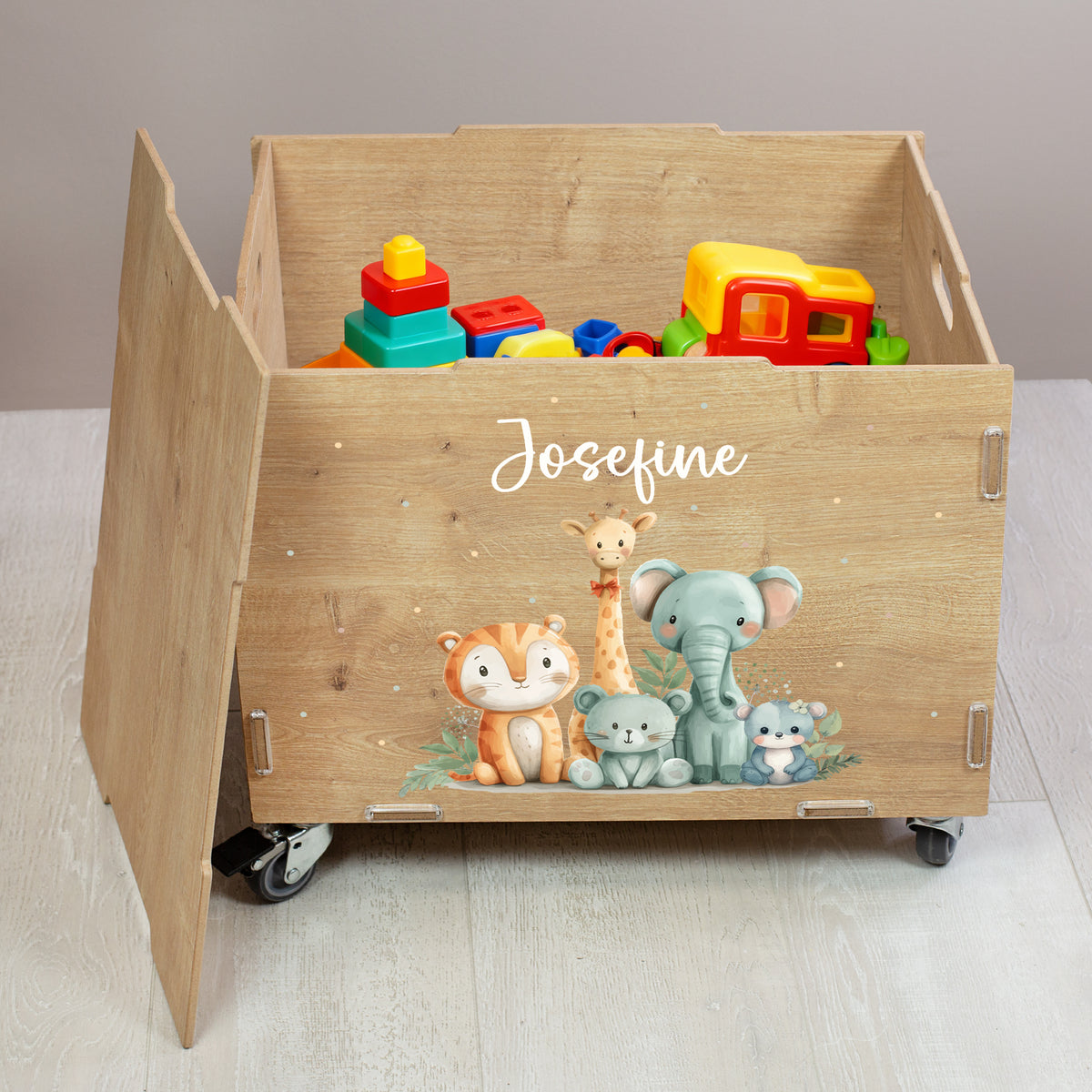 Offene Rollkiste aus Holz mit Tierfreunde-Motiv und personalisiertem Namen, gefüllt mit Spielzeug, seitliche Ansicht