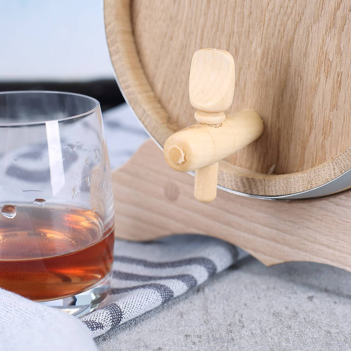 Holzfass besitzt einen Auslass-Hahn um Schnaps problemlos und einfach in Schnapsglas füllen zu können