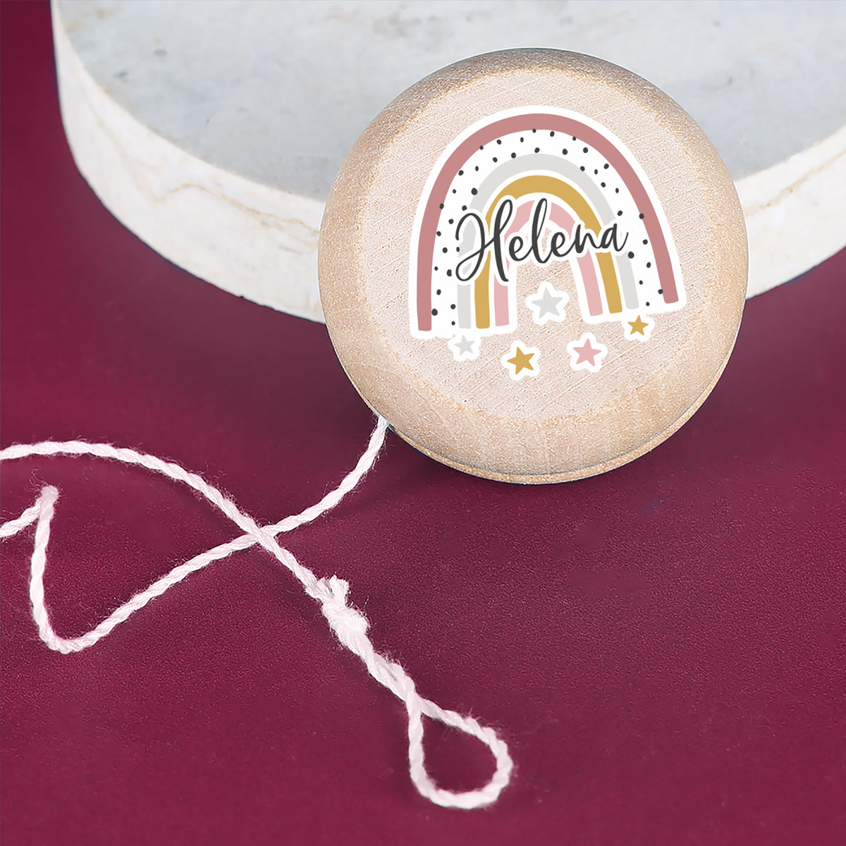 Yo-Yo mit Regenbogen-Motiv und Name Helena, aufgestellt auf Marmorplatte