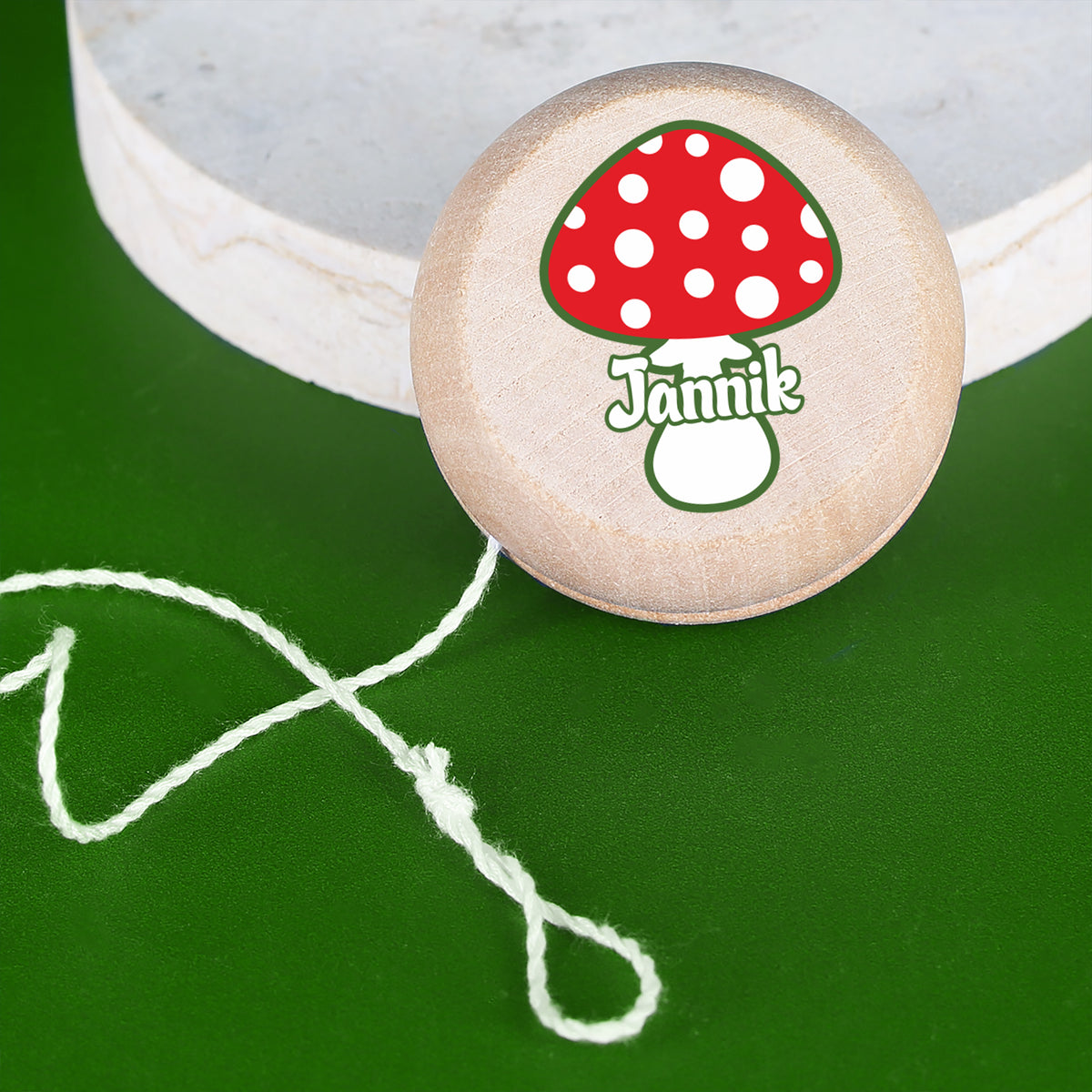 Yo-Yo aus Holz mit Glückspilz-Motiv, Ansicht von oben mit rotem Pilz und personalisiertem Namen