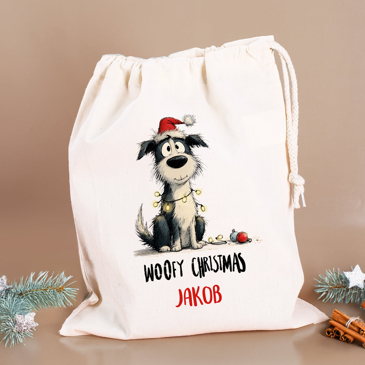 Personalisierter Geschenksack mit Hundemotiv „Woofy Christmas – Jakob“, dekoriert mit Tannenzweigen und Zimtstangen