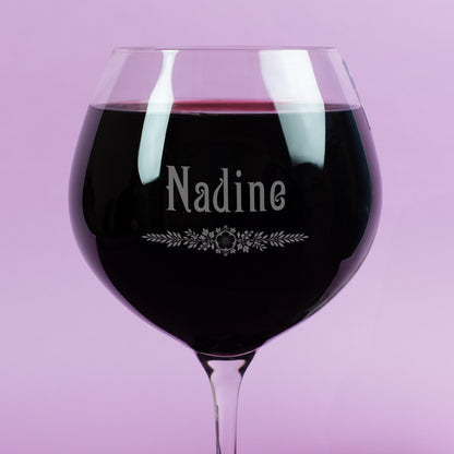 Detailaufnahme des Burgunderglases von Leonardo mit Gravur des Namens Nadine und feinem Blätter-Ornament – hochwertige Gravur im Glas, gefüllt mit Rotwein.