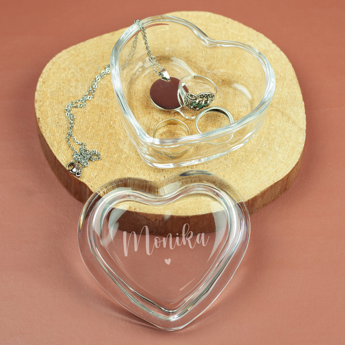 Gravierte Glasdose in Herzform mit Name Monika und Schmuck auf Holzunterlage